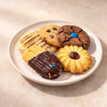 Assorted sweet cookies on a white plate with a beige background